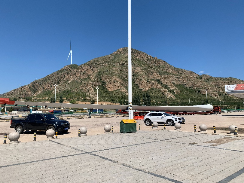 服务区中，运送风车叶片的超长挂车